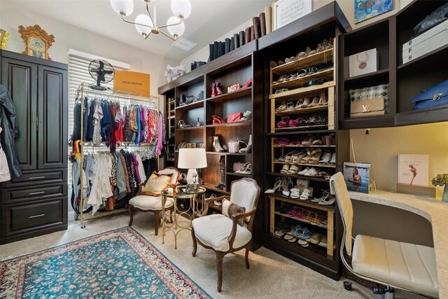 walk in closet with a notable chandelier