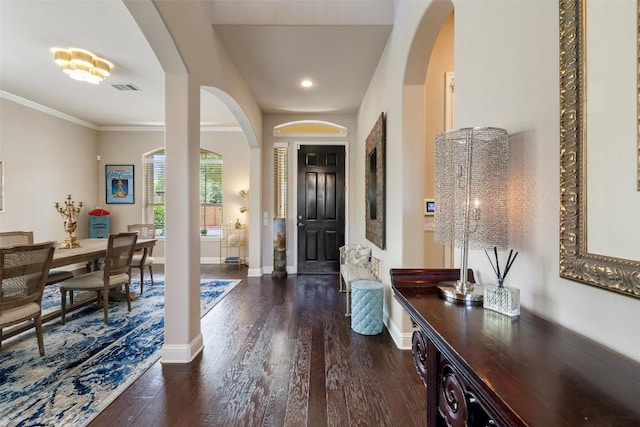 foyer entrance featuring arched walkways, baseboards, dark wood-type flooring, visible vents, and recessed lighting