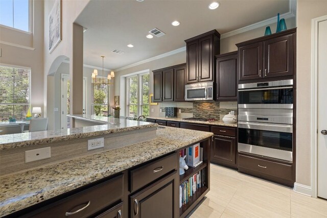 kitchen featuring stainless steel appliances, visible vents, a sink, tasteful backsplash, and a notable chandelier