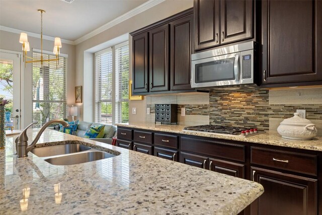 kitchen with dark brown cabinets, stainless steel appliances, a sink, and tasteful backsplash