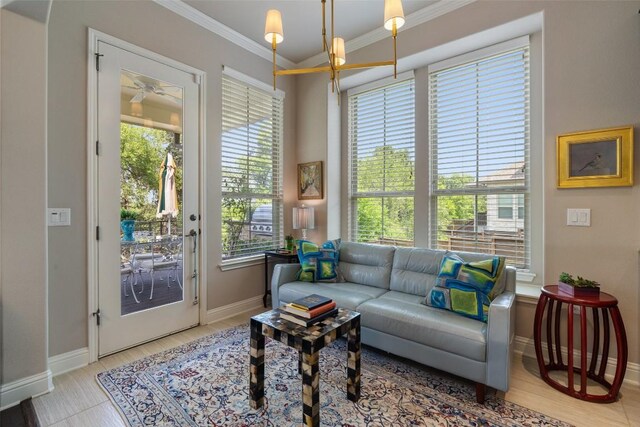 interior space with a ceiling fan, a wealth of natural light, ornamental molding, and baseboards