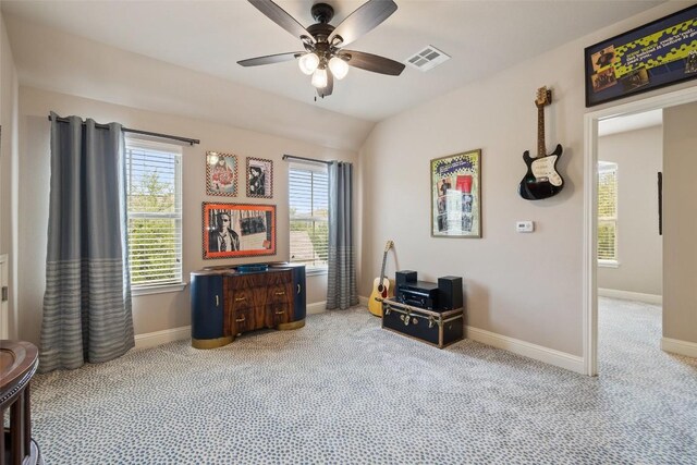 office space featuring baseboards, visible vents, ceiling fan, and light colored carpet