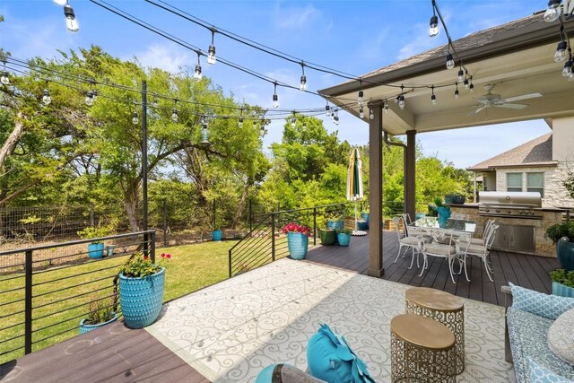 deck featuring outdoor dining space, a lawn, area for grilling, and ceiling fan