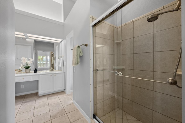 full bathroom with tile patterned floors, baseboards, vanity, and a shower stall
