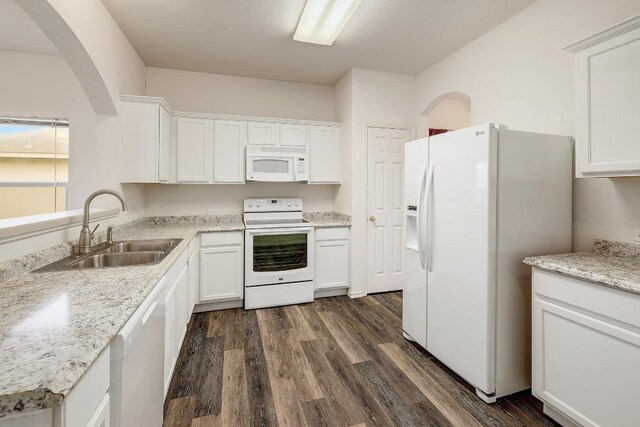 kitchen with dark wood-type flooring, white cabinetry, a sink, and white appliances