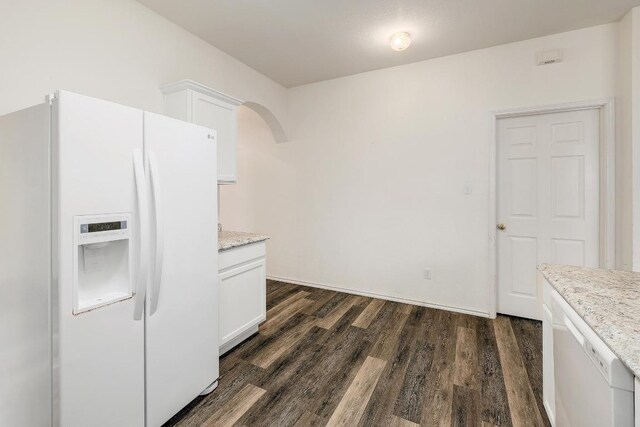 kitchen with white cabinets, arched walkways, dark wood-style flooring, white appliances, and light stone counters