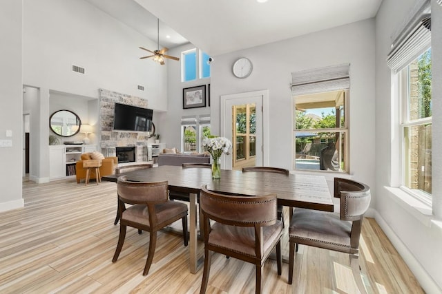 20401 Great Egret Ln, Pflugerville, TX 78660 - dining area with a ceiling fan, a fireplace, plenty of natural light, and a towering ceiling
