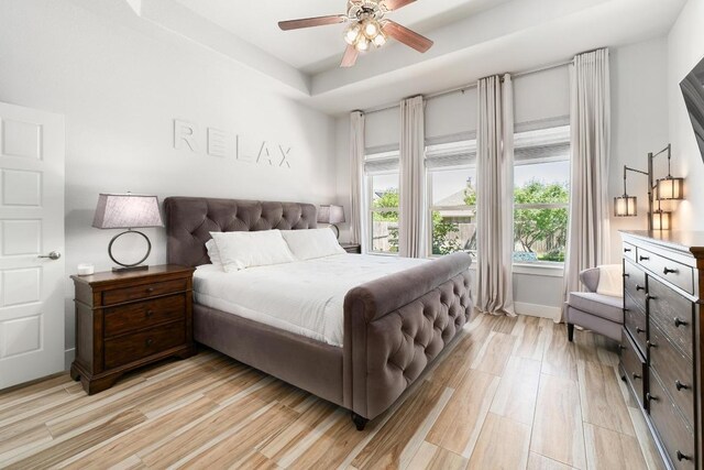 20401 Great Egret Ln, Pflugerville, TX 78660 - bedroom featuring light wood-style flooring, ceiling fan, and a tray ceiling