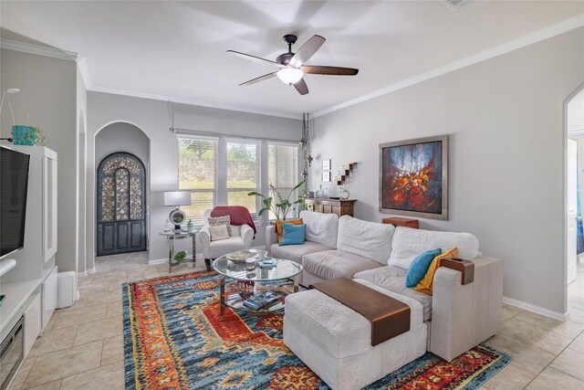living area featuring arched walkways, ceiling fan, baseboards, and ornamental molding