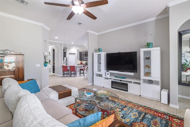 living area featuring arched walkways, visible vents, tile patterned floors, and ceiling fan