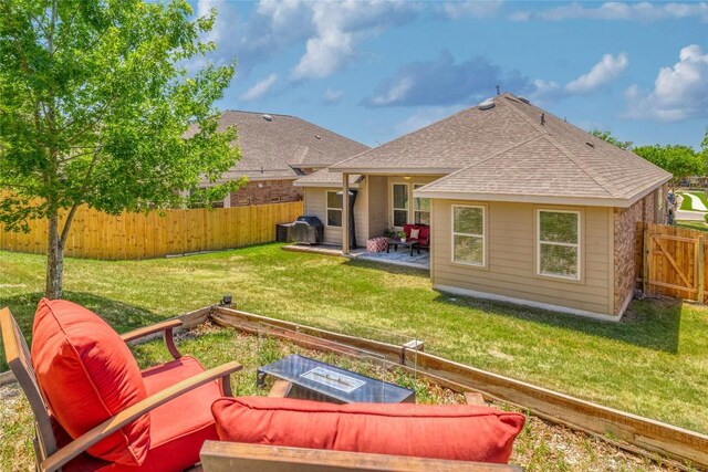 back of house with a fenced backyard, a patio area, a shingled roof, and a yard