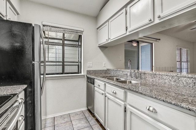 2215 Post Rd Unit 2022, Austin, TX 78704 - kitchen with a sink, stainless steel appliances, baseboards, light tile patterned floors, and light stone counters