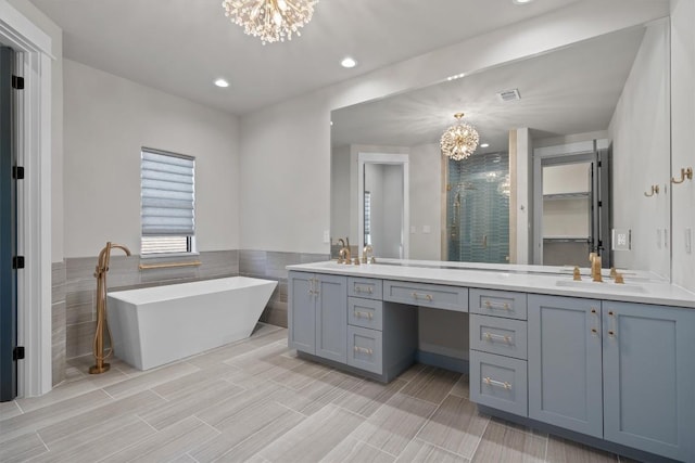 8 Cove Creek Ln, Austin, TX 78738 - full bathroom featuring a chandelier, tile walls, double vanity, a stall shower, and a soaking tub