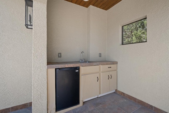 8 Cove Creek Ln, Austin, TX 78738 - indoor wet bar with wooden ceiling, refrigerator, and dark tile patterned floors