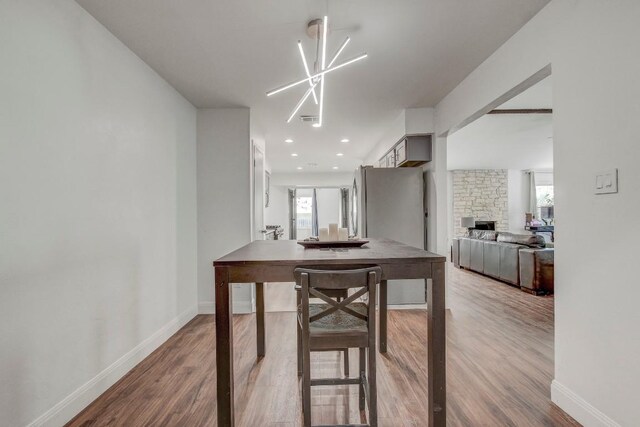 12319 Wycliff Ln, Austin, TX 78727 - dining area featuring wood finished floors, healthy amount of natural light, baseboards, and a stone fireplace