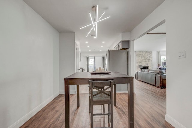 12319 Wycliff Ln, Austin, TX 78727 - dining area featuring wood finished floors, healthy amount of natural light, baseboards, and a stone fireplace