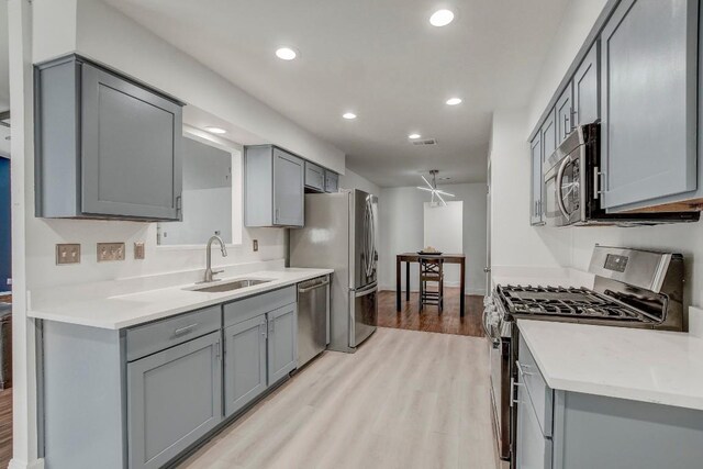 12319 Wycliff Ln, Austin, TX 78727 - kitchen with stainless steel appliances, a sink, gray cabinetry, light wood-type flooring, and recessed lighting
