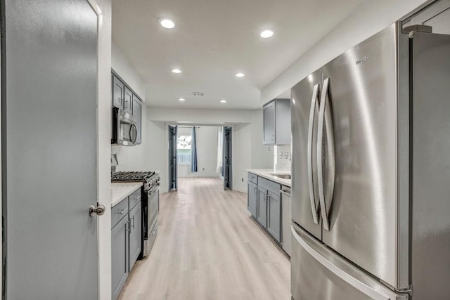 12319 Wycliff Ln, Austin, TX 78727 - kitchen featuring stainless steel appliances, gray cabinetry, light wood-style flooring, recessed lighting, and light countertops
