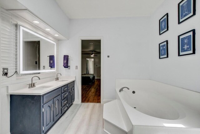 12319 Wycliff Ln, Austin, TX 78727 - full bath featuring wood finished floors, double vanity, a garden tub, ensuite bathroom, and baseboards