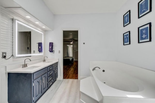12319 Wycliff Ln, Austin, TX 78727 - full bath featuring wood finished floors, double vanity, a garden tub, ensuite bathroom, and baseboards