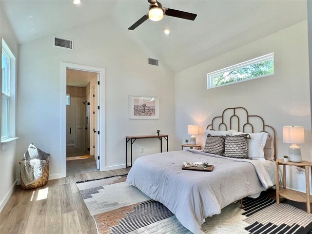 bedroom with high vaulted ceiling, wood finished floors, visible vents, and baseboards