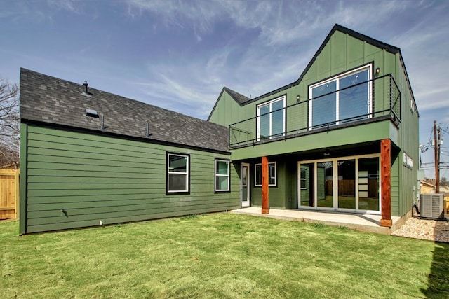 rear view of property with a lawn, a balcony, cooling unit, and a patio