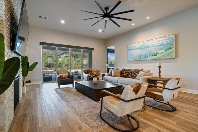 2500 Yuma Trl, Leander, TX 78641 - living room with a fireplace, light wood-style floors, a ceiling fan, and recessed lighting