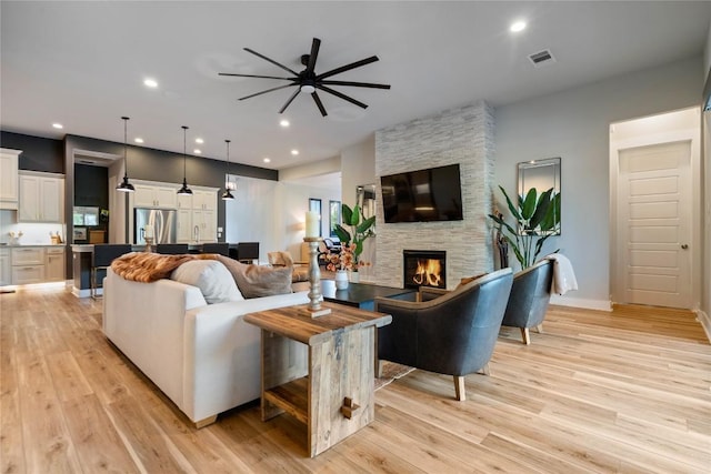 2500 Yuma Trl, Leander, TX 78641 - living area featuring a ceiling fan, light wood-style flooring, recessed lighting, and a stone fireplace