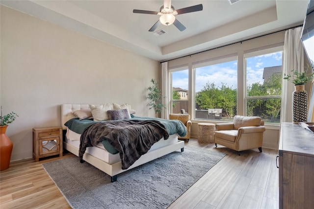 2500 Yuma Trl, Leander, TX 78641 - bedroom featuring a tray ceiling, light wood-style flooring, and a ceiling fan