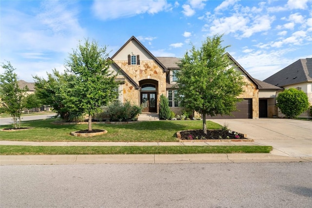 2500 Yuma Trl, Leander, TX 78641 - view of front of property with stone siding, french doors, driveway, an attached garage, and a front lawn