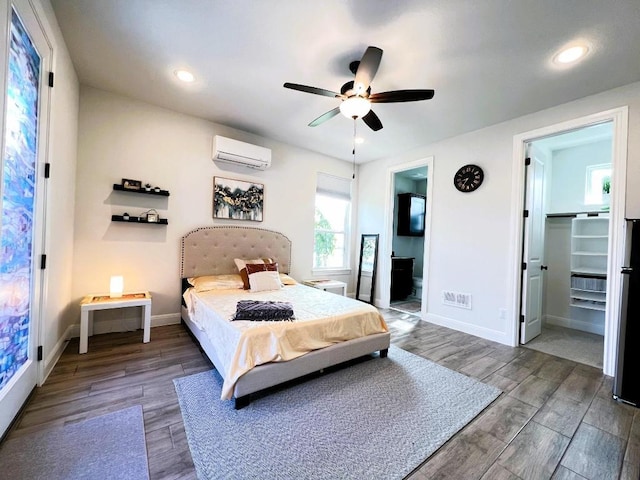 4201 Arques Ave, Round Rock, TX 78681 - bedroom featuring a wall mounted air conditioner, wood finished floors, baseboards, ensuite bathroom, and a ceiling fan