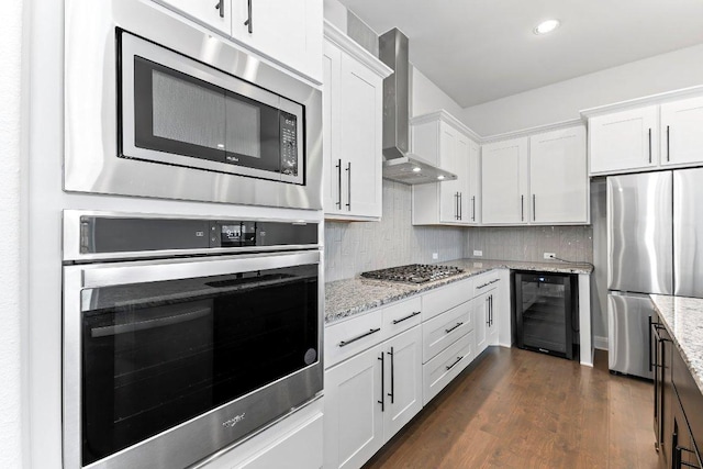 4201 Arques Ave, Round Rock, TX 78681 - kitchen featuring appliances with stainless steel finishes, wine cooler, wall chimney exhaust hood, white cabinetry, and tasteful backsplash