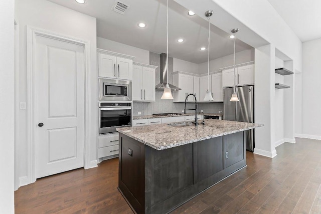 4201 Arques Ave, Round Rock, TX 78681 - kitchen featuring appliances with stainless steel finishes, wall chimney exhaust hood, white cabinetry, dark wood-style floors, and recessed lighting