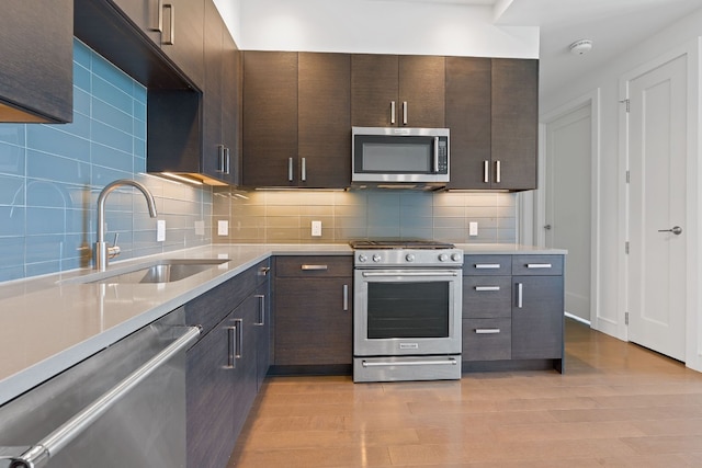 222 W Ave Unit 1412, Austin, TX 78701 - kitchen with appliances with stainless steel finishes, a sink, light countertops, dark brown cabinets, and decorative backsplash