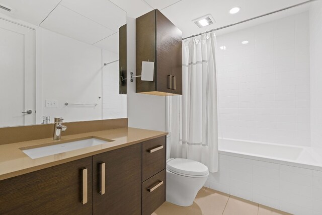 bathroom with tile patterned floors, tiled shower / bath, visible vents, toilet, and vanity