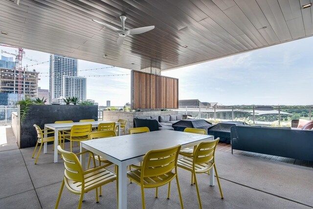 view of patio / terrace with outdoor dining area, a city view, and a ceiling fan