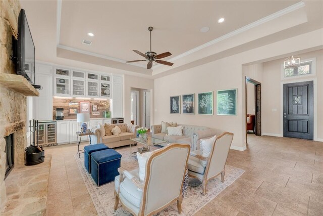 living area with a raised ceiling, visible vents, and crown molding