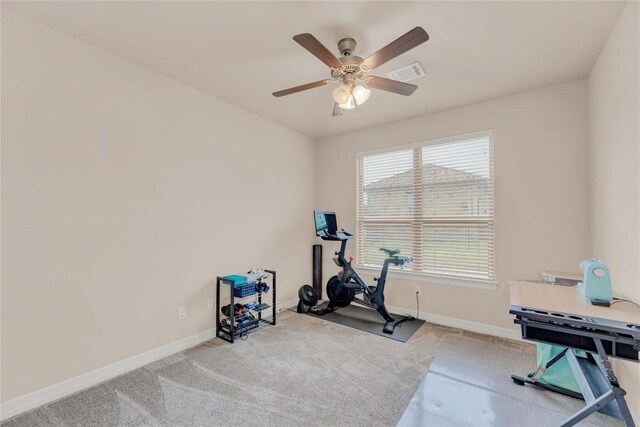 exercise area with baseboards, a ceiling fan, carpet flooring, and visible vents