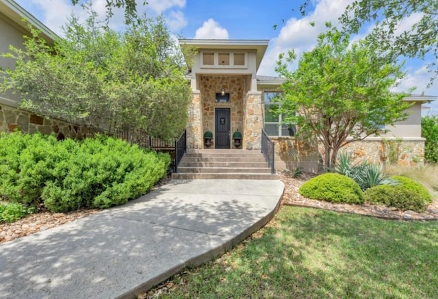 property entrance with stone siding and stucco siding