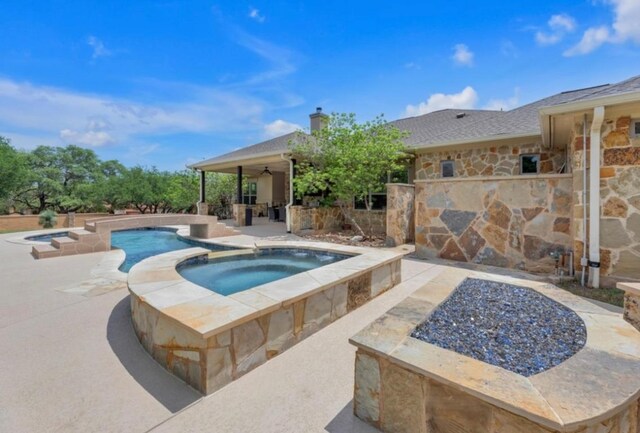 view of swimming pool featuring a fire pit, a ceiling fan, a patio area, and a pool with connected hot tub