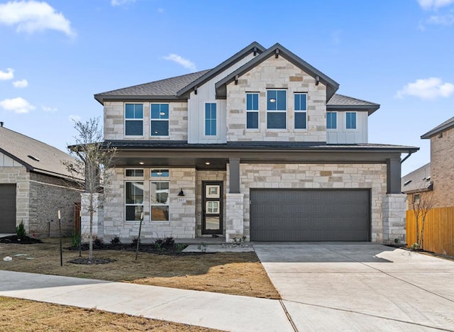 view of front of house with stone siding, concrete driveway, fence, a garage, and a shingled roof
