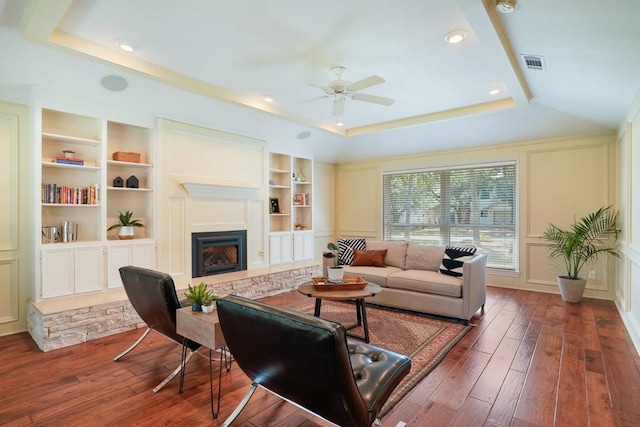 11204 Deadoak Ln, Austin, TX 78759 - living room featuring built in shelves, a ceiling fan, hardwood / wood-style floors, a fireplace with raised hearth, and recessed lighting
