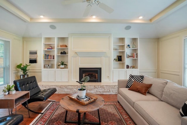 11204 Deadoak Ln, Austin, TX 78759 - living area featuring wood finished floors, a raised ceiling, built in shelves, and crown molding