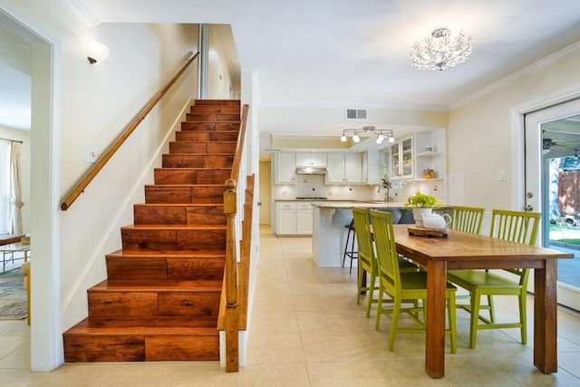 11204 Deadoak Ln, Austin, TX 78759 - staircase with ornamental molding, tile patterned flooring, and a chandelier