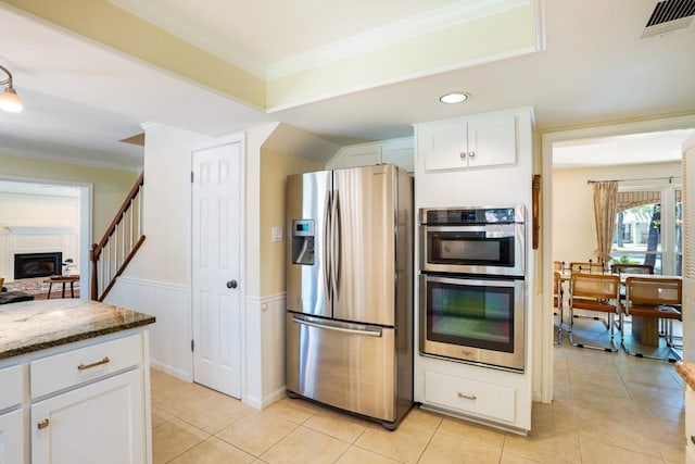 11204 Deadoak Ln, Austin, TX 78759 - kitchen with appliances with stainless steel finishes, stone counters, white cabinets, crown molding, and light tile patterned flooring