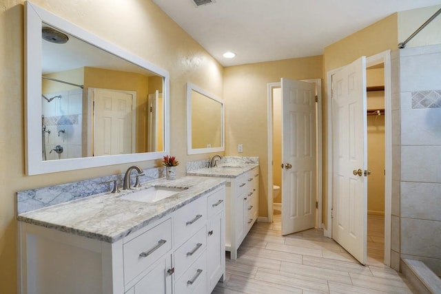 11204 Deadoak Ln, Austin, TX 78759 - full bath with double vanity, tiled shower, and a spacious closet