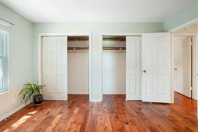 11204 Deadoak Ln, Austin, TX 78759 - unfurnished bedroom with two closets and wood-type flooring