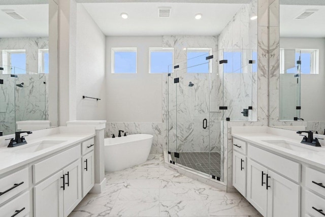 4216 Caroline Mae Cv, Pflugerville, TX 78660 - bathroom with a marble finish shower, two vanities, a freestanding bath, marble finish floors, and recessed lighting