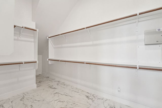 walk in closet featuring marble finish floor