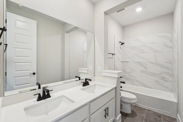 bathroom with visible vents, a sink, double vanity, and toilet